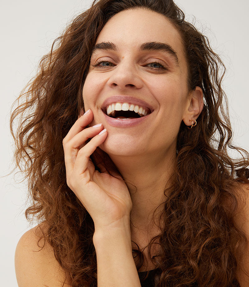 Model with long curly hair smiling