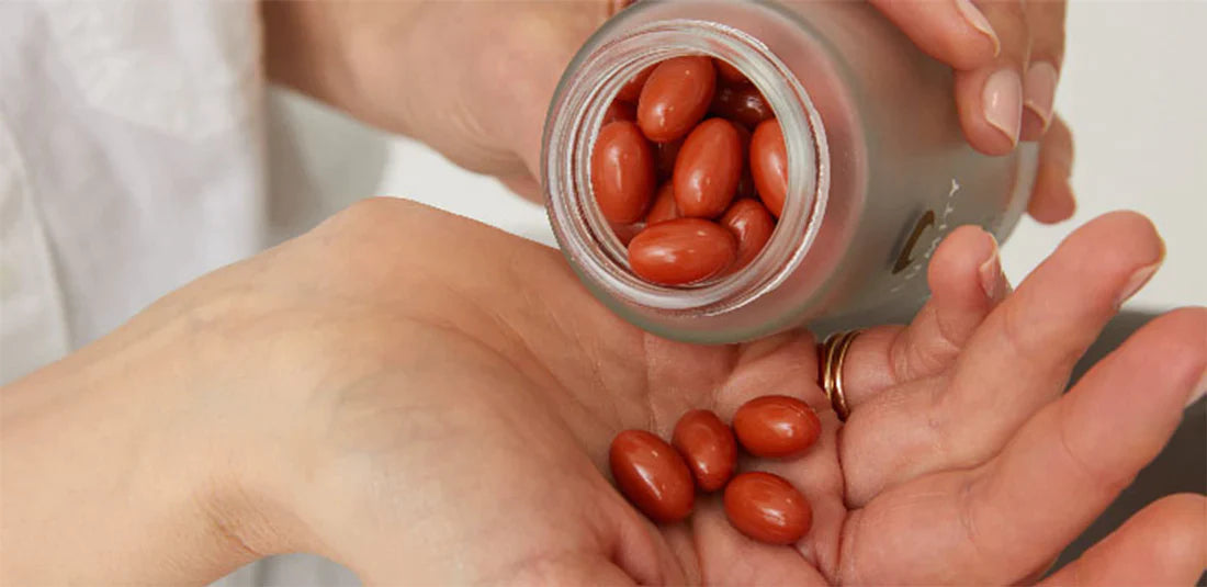 Woman pouring lumity morning softgels on to hand from frosted glass bottle