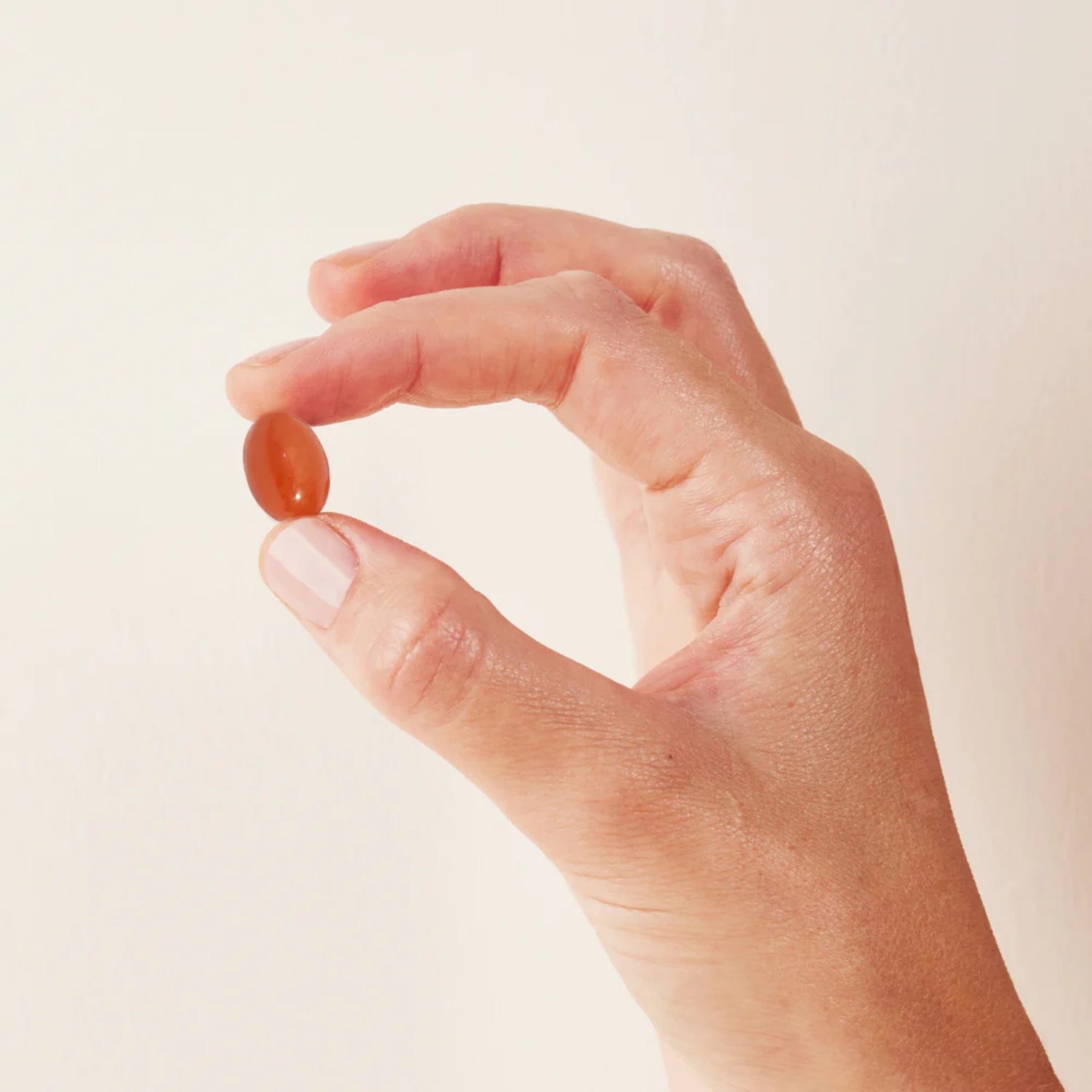 Hand holding a softgel from Morning & Night Women's Supplement for daily wellness and vitality support