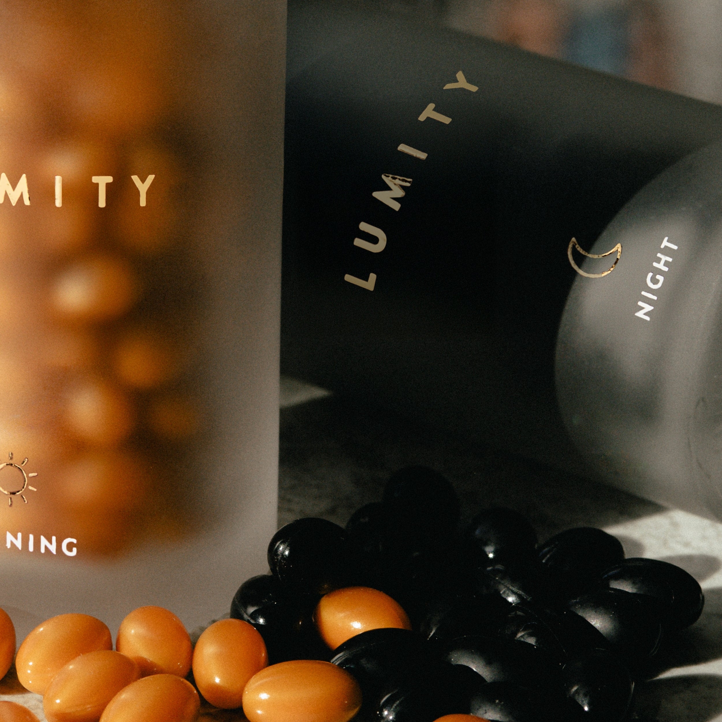 Morning and night Lumity supplements with orange and black softgels for men's daily wellness and energy support