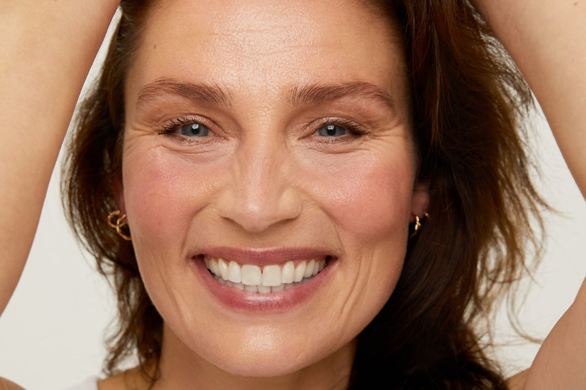 Close-up of a woman with a bright smile against a neutral background