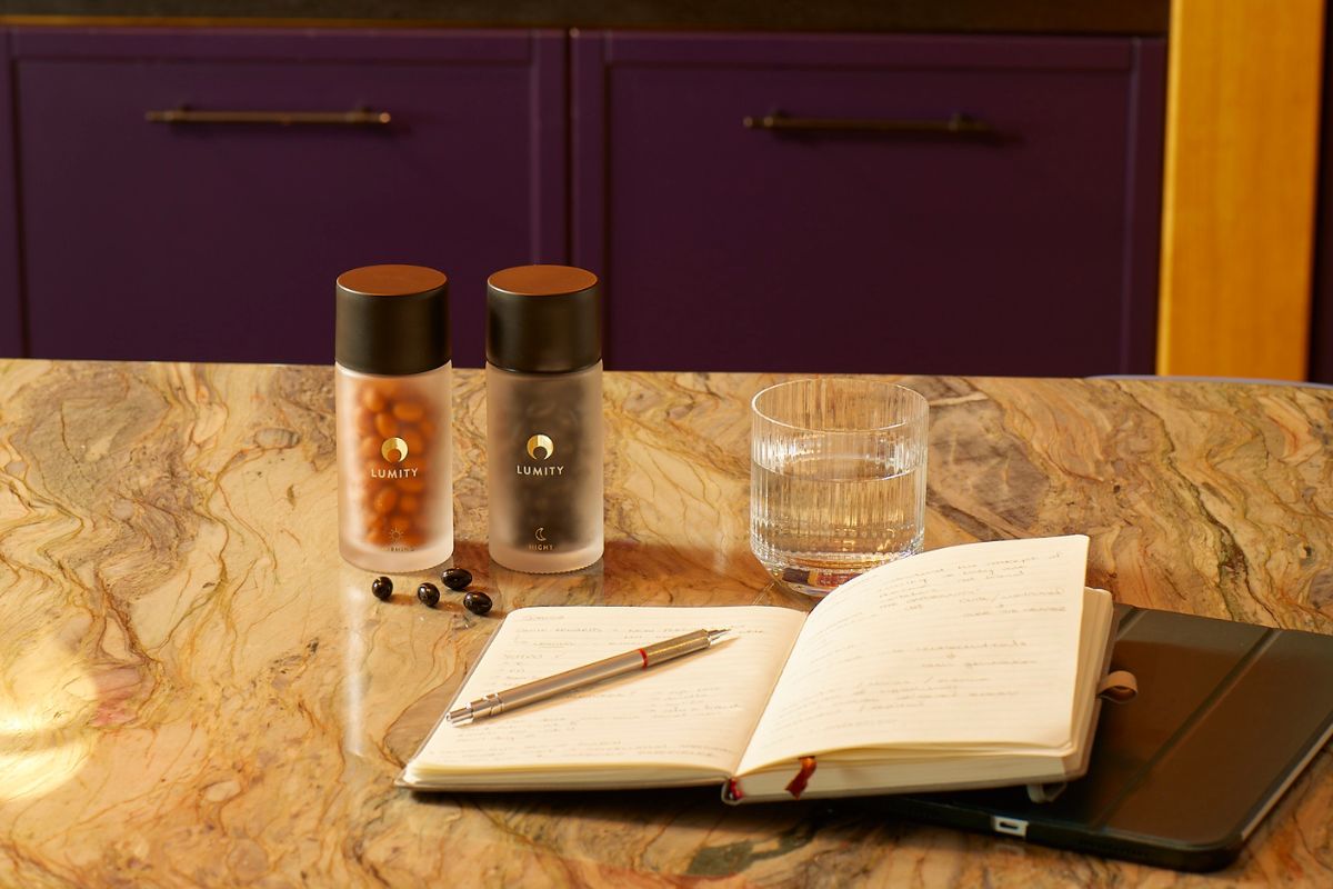 Morning & Night supplements on worktop with open note book and glass of water