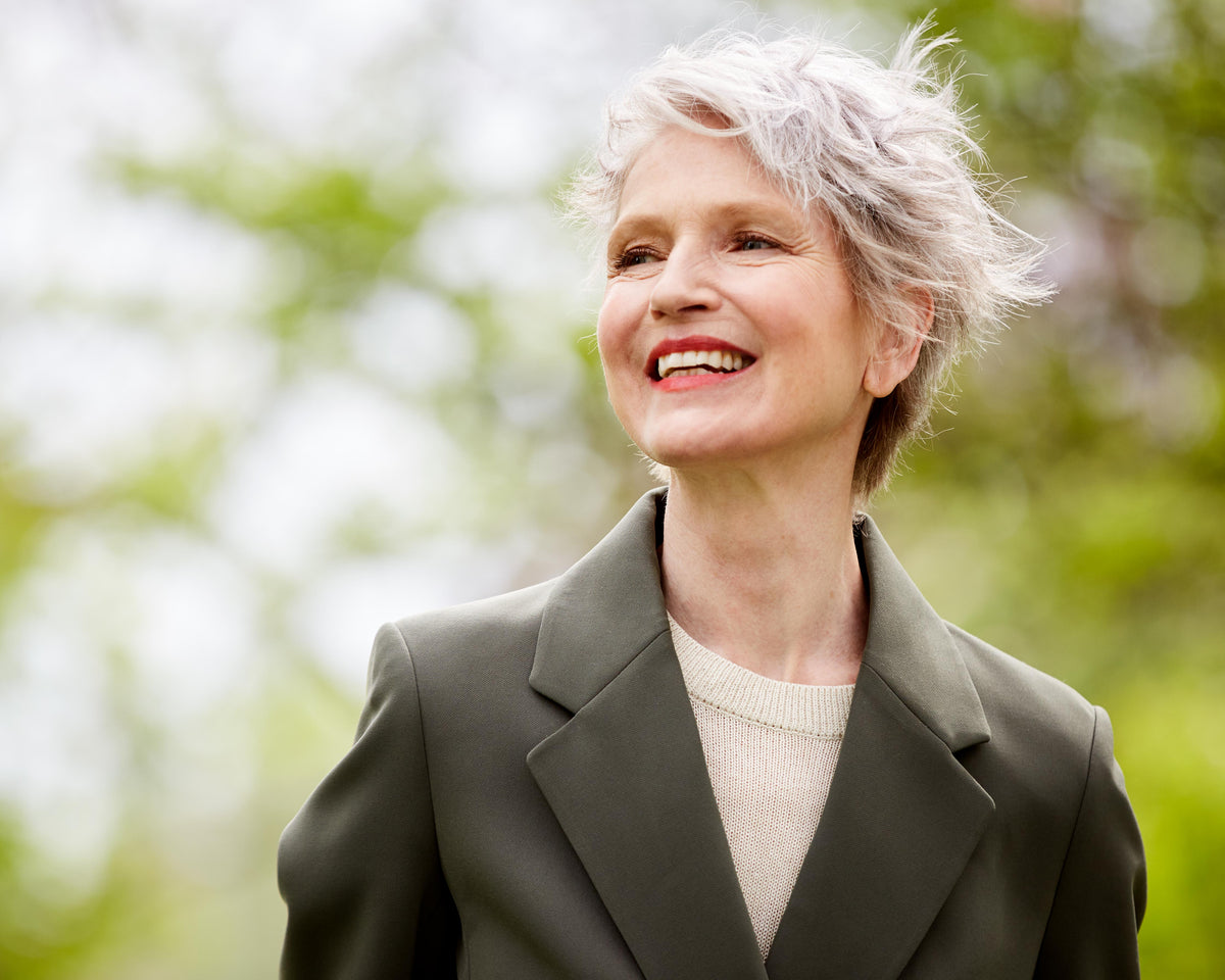 Smiling mature woman with short gray hair standing outside