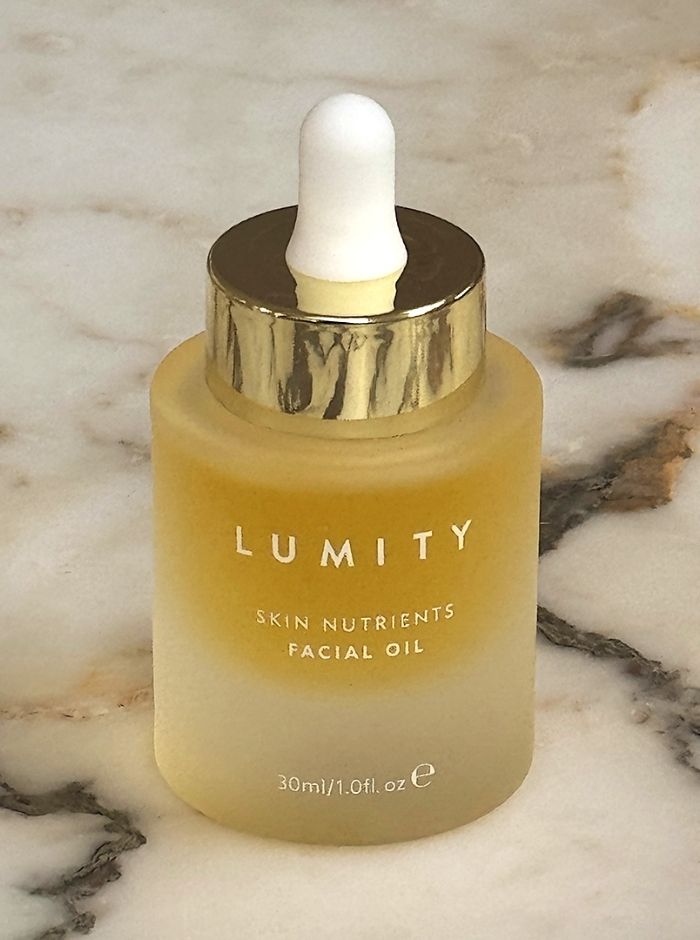 Lumity facial oil bottle on a marble surface