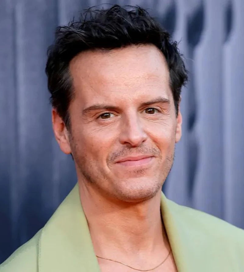 Actor Andrew Scott smiling, wearing light green jacket against a blue background