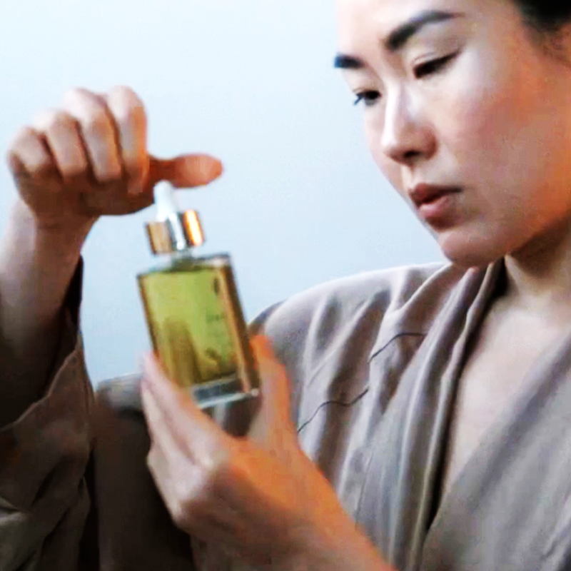 Woman holding a bottle of Lumity Skin Nutrients Body Oil