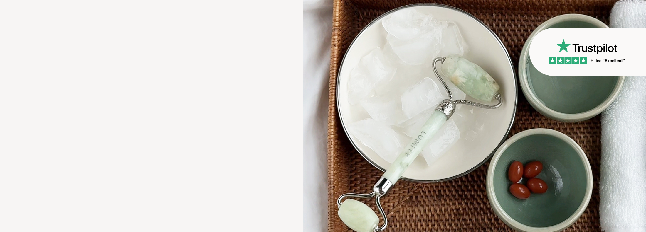 Flat lay of a jade facial roller, softgel capsules, ice cubes on a tray, with a Trustpilot rating badge visible.