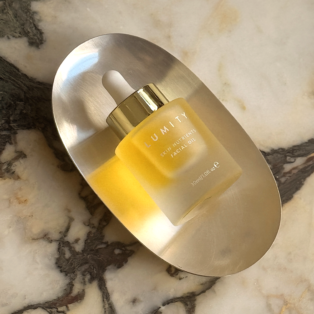 Facial oil bottle with dropper on a marble surface