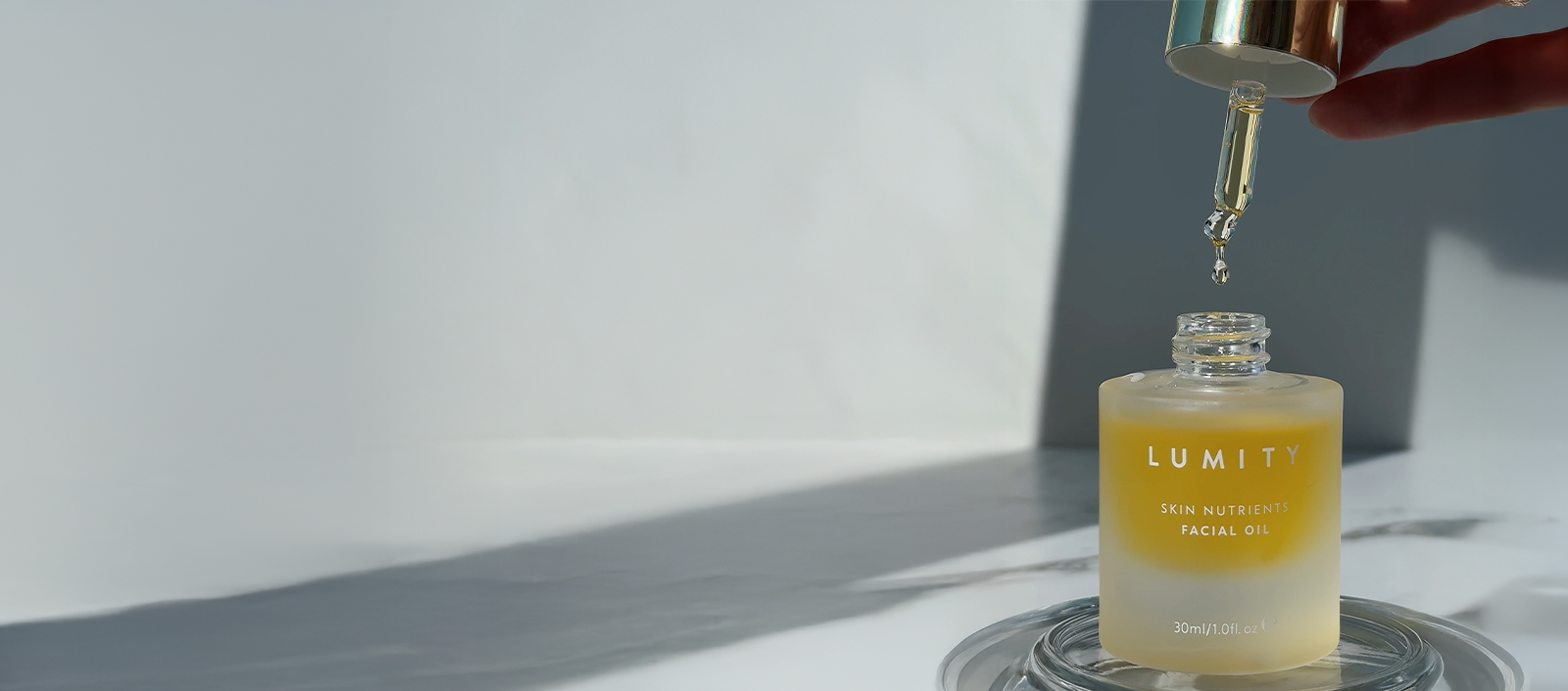 Lumity Skin Nutrients Facial Oil with pipette coming out of bottle