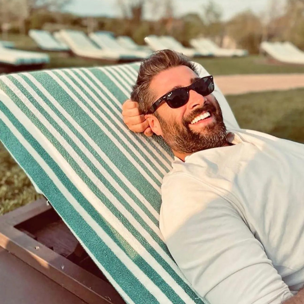 Matt Johnson sitting on deck chair in sunglasses