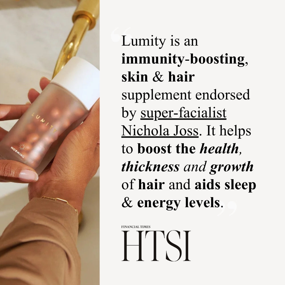 Hand holding semi-transparent Lumity bottle with white cap and capsules, brown sleeve and gold bracelet, text and FT logo