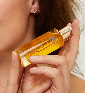 Woman holding bottle of facial oil